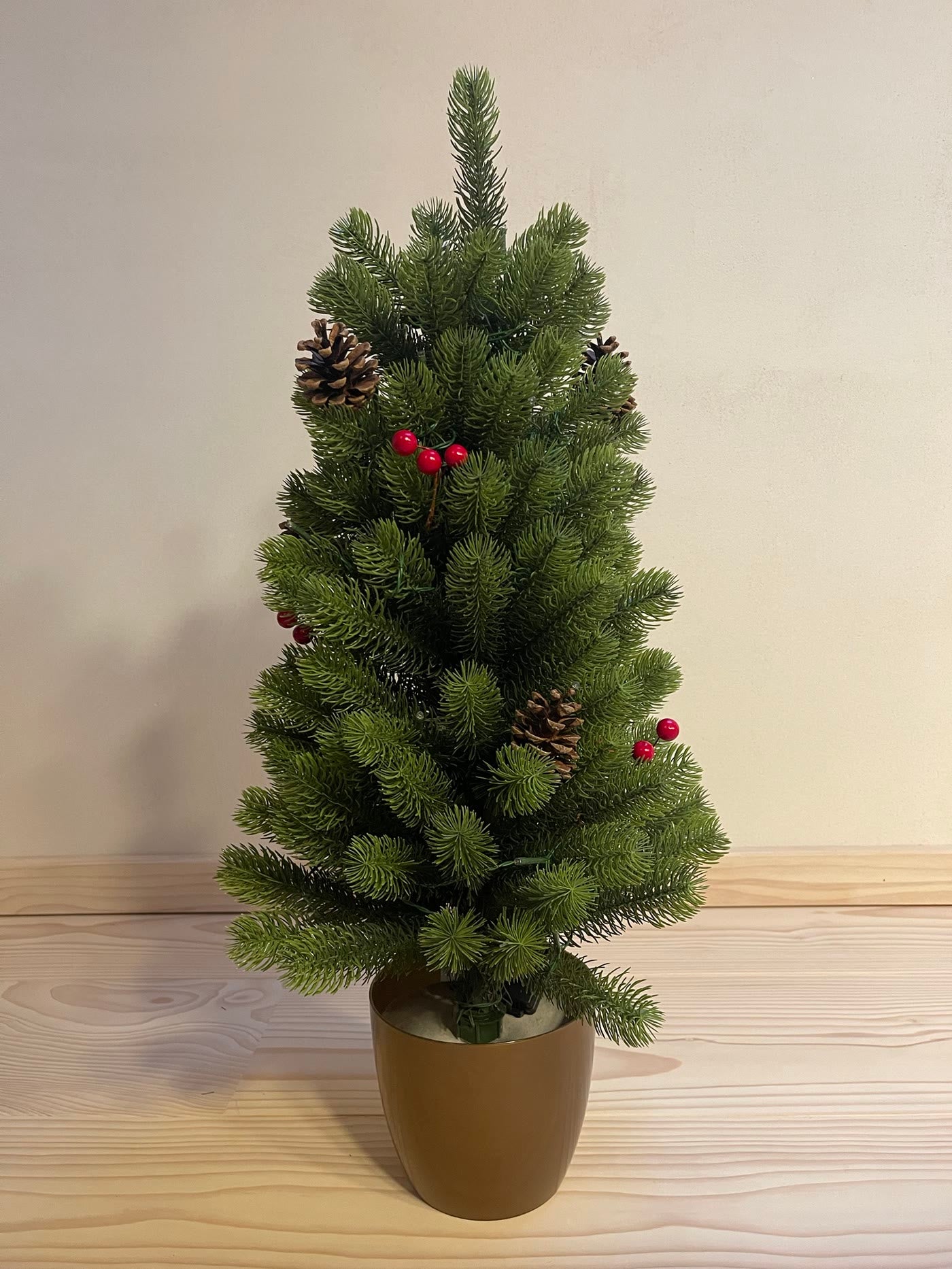 Pinito without lights, pine cones and red berries, in a gold pot